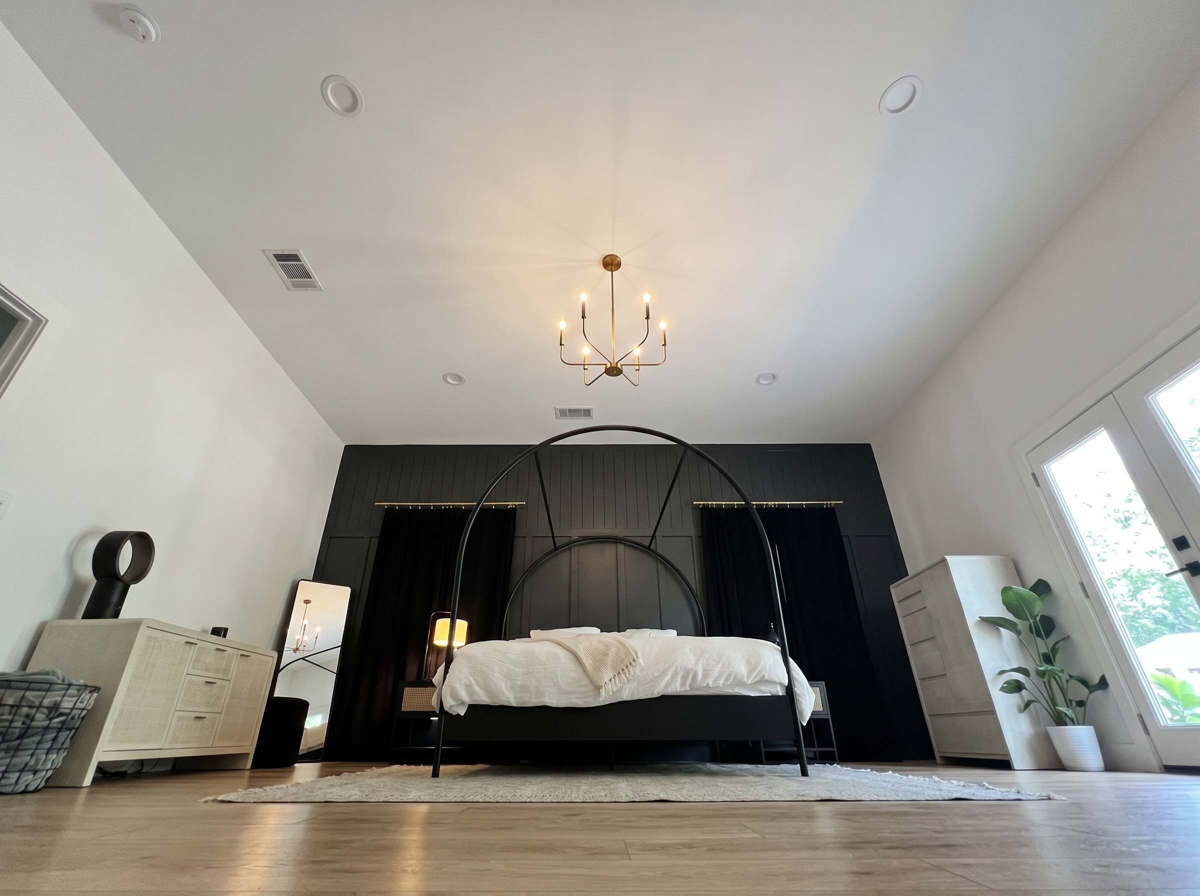 Floor-to-ceiling view of primary bedroom showing coffered ceiling, chandelier and hardwood floors — May Construction