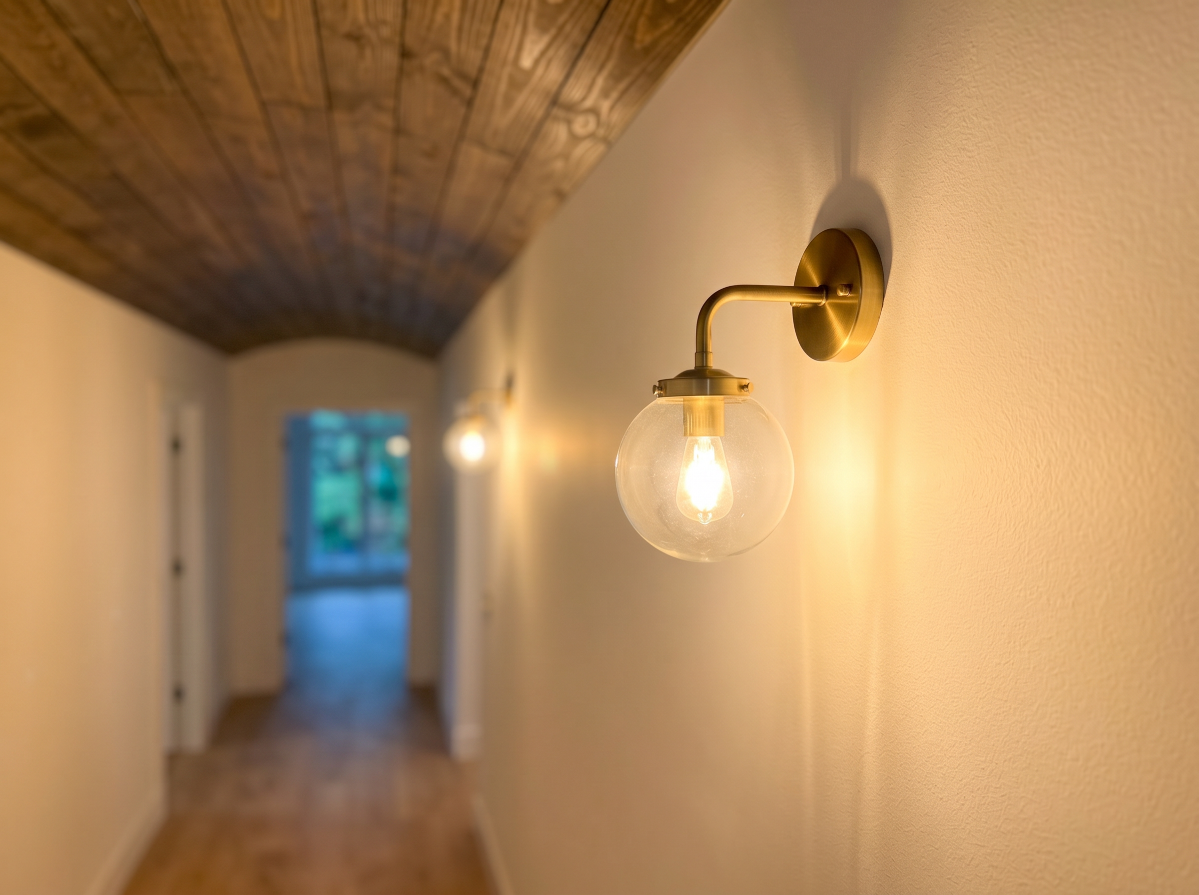 Brass globe wall sconce lighting detail in custom hallway with shiplap ceiling — May Construction