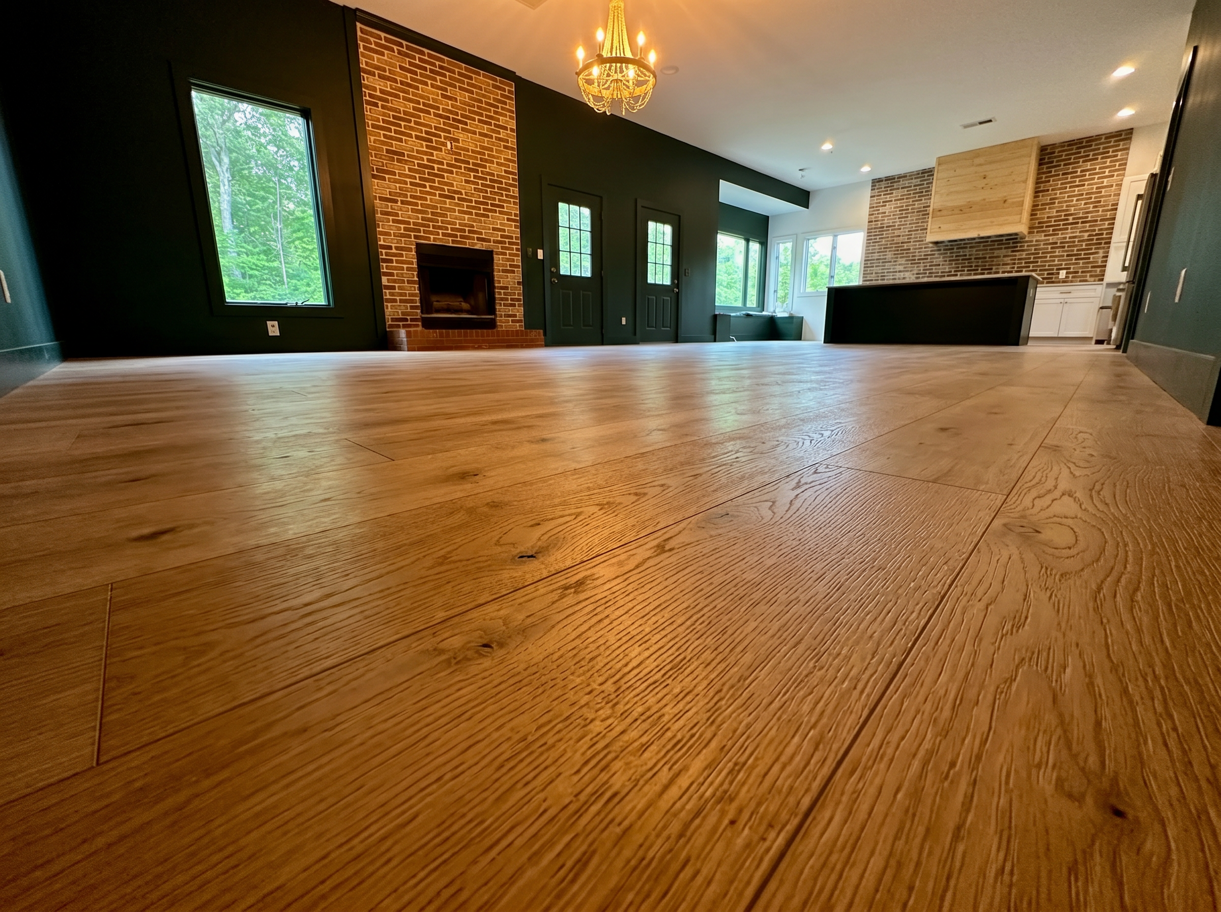 Wide-plank hardwood floor installation in open concept living room — precision craftsmanship — May Construction